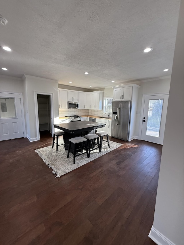 dining room featuring sink, crown molding, dark hardwood / wood-style floors, and a textured ceiling