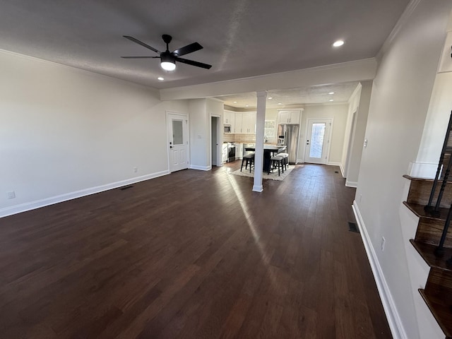 unfurnished living room featuring decorative columns, ceiling fan, ornamental molding, and dark hardwood / wood-style flooring