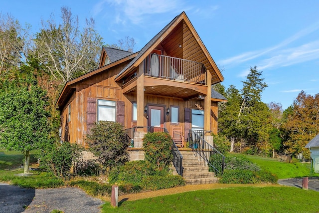 view of front of property with a balcony and a front yard