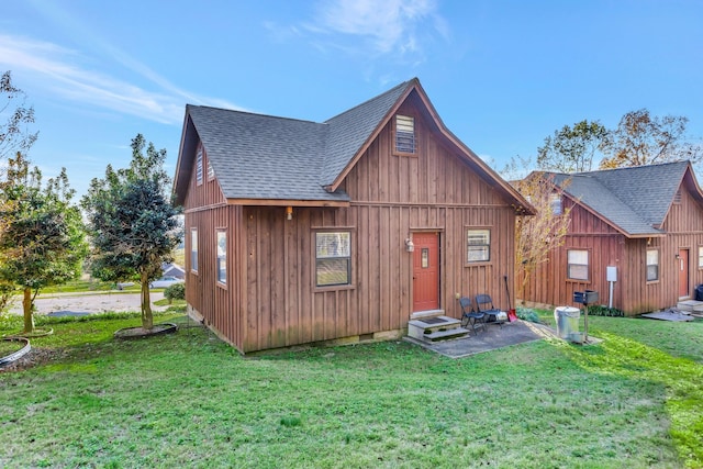 rear view of property featuring a lawn