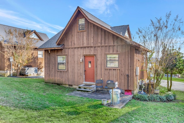 rear view of property with central AC and a lawn