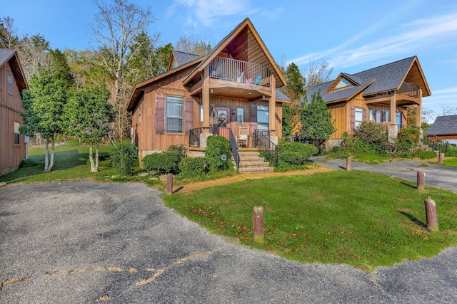 view of front of house with a balcony and a front yard