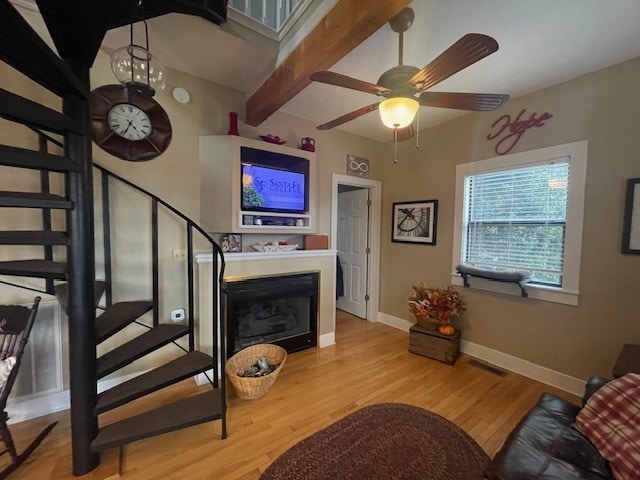 living room with beamed ceiling, ceiling fan, and light hardwood / wood-style floors