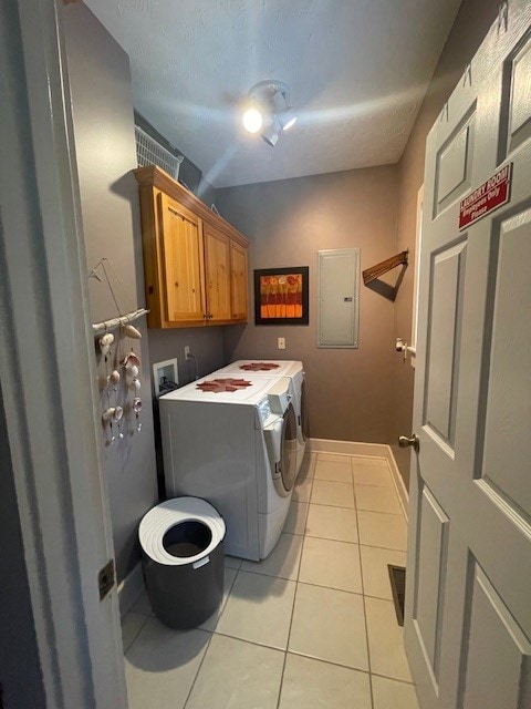 laundry area featuring light tile patterned flooring, cabinets, electric panel, independent washer and dryer, and a textured ceiling