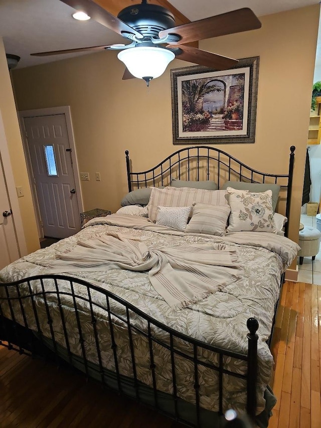 bedroom with dark hardwood / wood-style flooring and ceiling fan