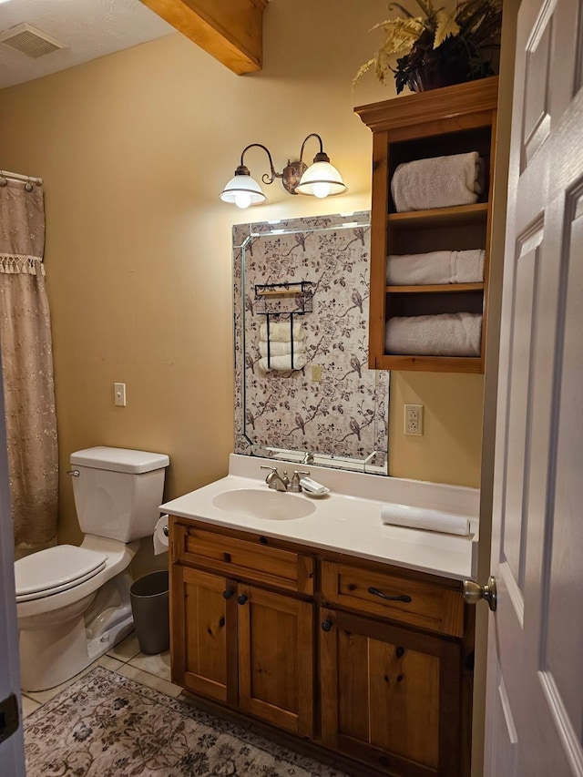 bathroom featuring vanity, tile patterned floors, and toilet