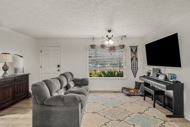 living room featuring light wood-type flooring, a textured ceiling, and ceiling fan