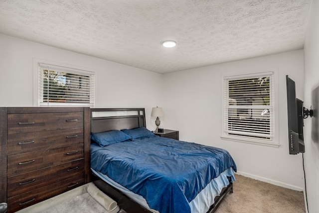 bedroom featuring light colored carpet and a textured ceiling