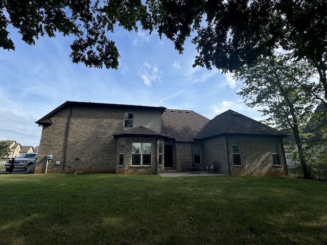 rear view of house featuring a patio area and a yard