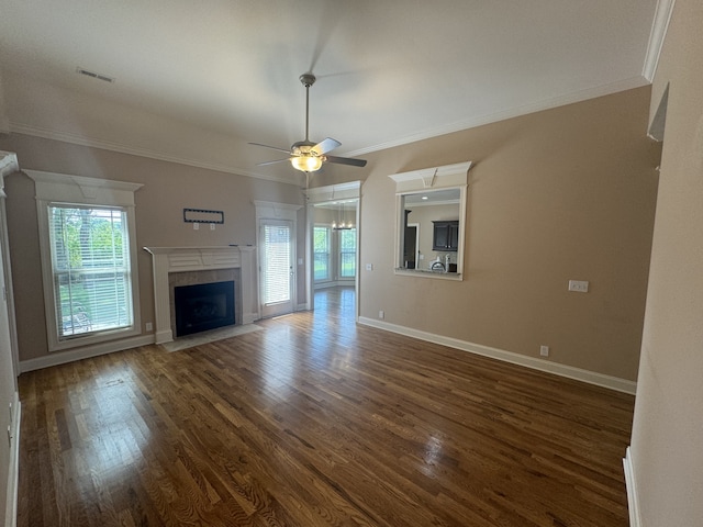 unfurnished living room with dark wood-type flooring, a wealth of natural light, ceiling fan, and a fireplace