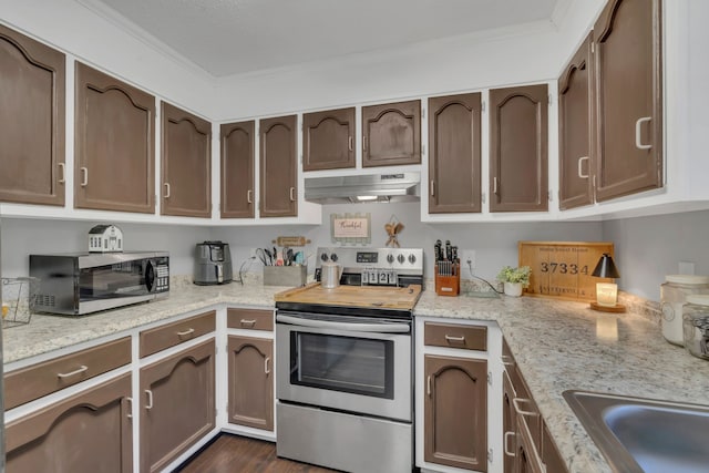 kitchen with light stone counters, dark wood-type flooring, stainless steel appliances, and ornamental molding