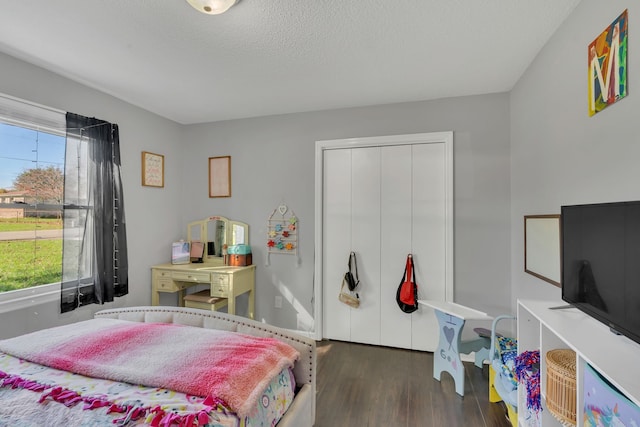 bedroom with a textured ceiling, a closet, and dark hardwood / wood-style floors