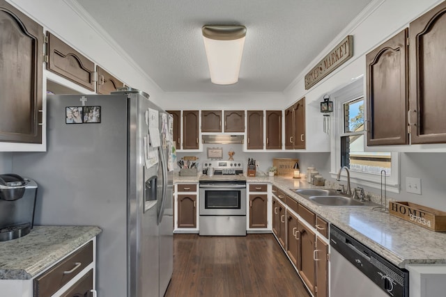 kitchen featuring sink, dark wood-type flooring, stainless steel appliances, crown molding, and a textured ceiling