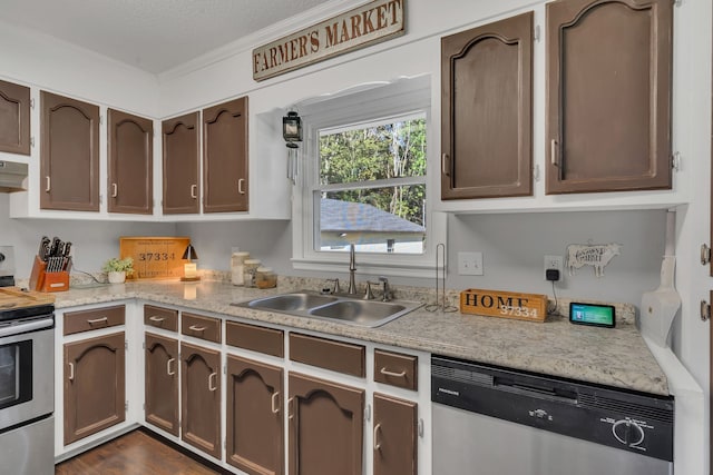 kitchen with ornamental molding, sink, dark wood-type flooring, a textured ceiling, and stainless steel appliances