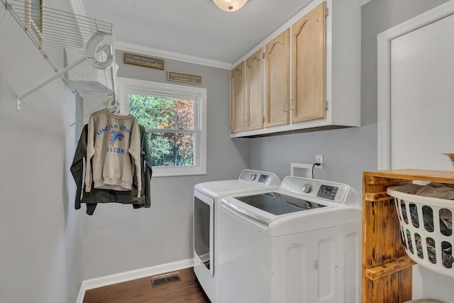 washroom featuring crown molding, cabinets, a textured ceiling, washing machine and clothes dryer, and dark hardwood / wood-style floors