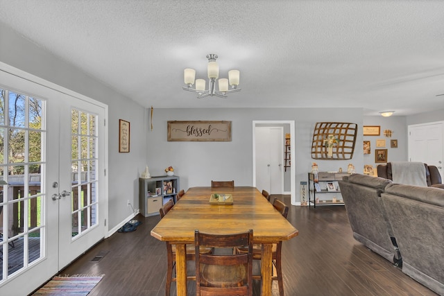 dining space with french doors, dark hardwood / wood-style flooring, a textured ceiling, and a notable chandelier