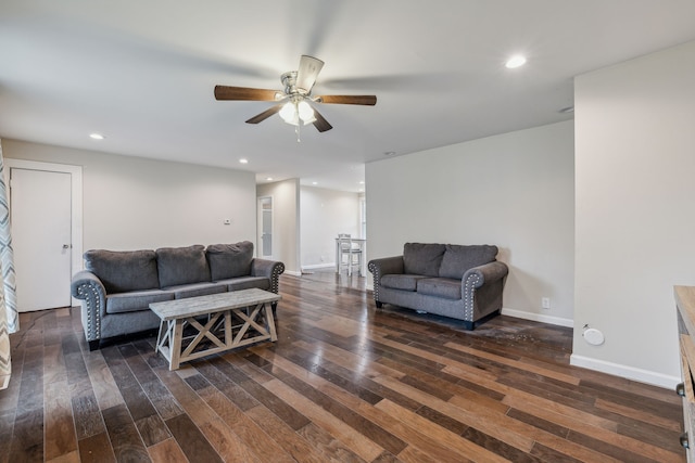 living room featuring dark wood-type flooring and ceiling fan