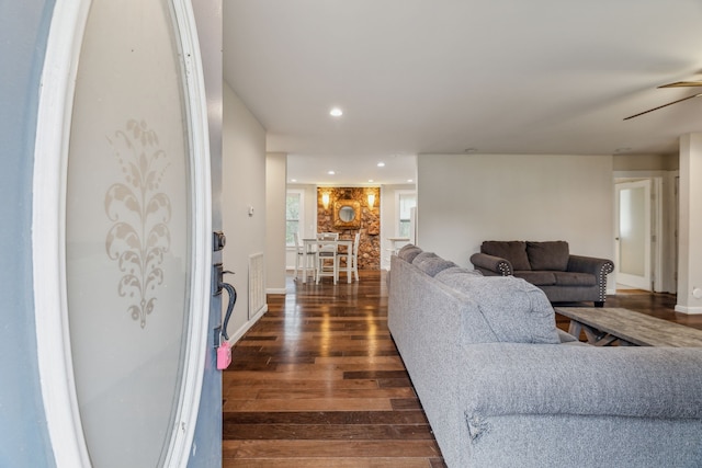 living room featuring dark wood-type flooring and ceiling fan