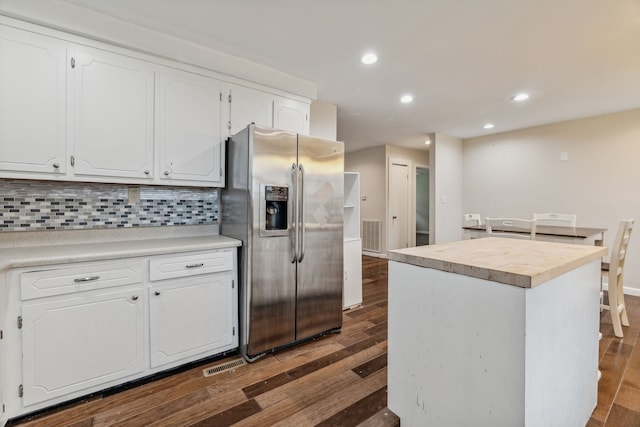 kitchen featuring dark hardwood / wood-style flooring, white cabinets, stainless steel refrigerator with ice dispenser, tasteful backsplash, and a kitchen island