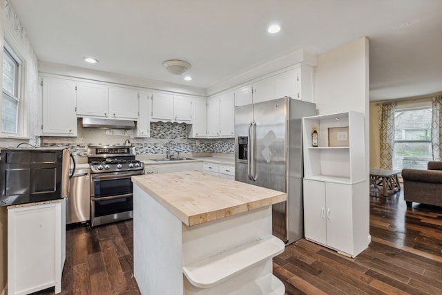 kitchen featuring stainless steel appliances, a center island, sink, dark hardwood / wood-style floors, and white cabinetry