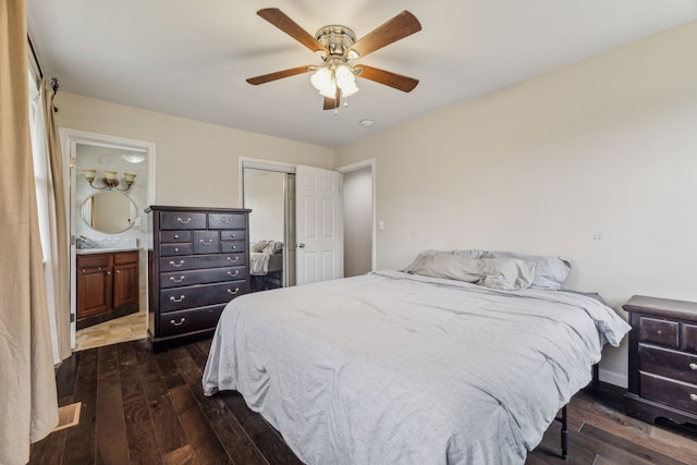 bedroom featuring ceiling fan, ensuite bath, and dark hardwood / wood-style flooring