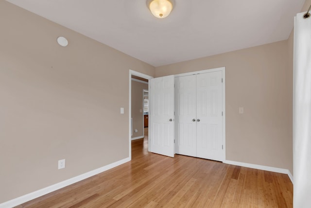 unfurnished bedroom with a closet and light wood-type flooring