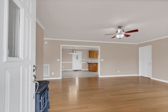 unfurnished living room featuring ceiling fan with notable chandelier, ornamental molding, and light hardwood / wood-style flooring