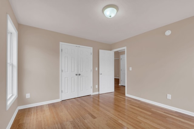 unfurnished bedroom with light hardwood / wood-style floors and a closet