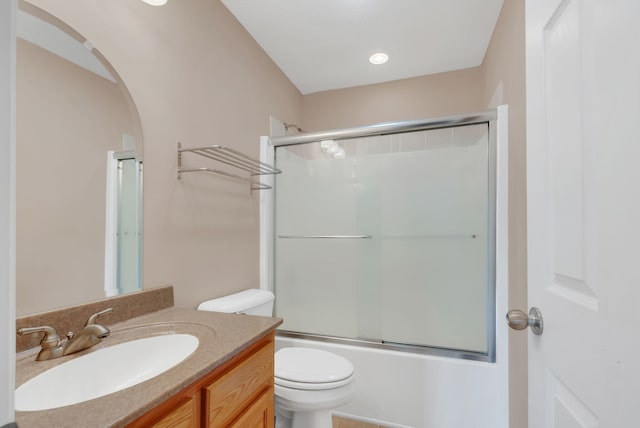 full bathroom featuring bath / shower combo with glass door, vanity, and toilet