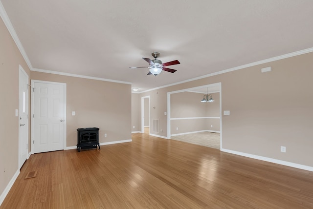 unfurnished living room with ceiling fan with notable chandelier, crown molding, light wood-type flooring, and a wood stove