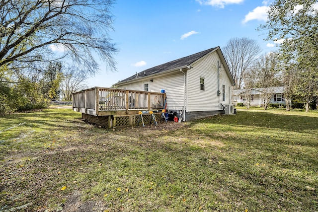 back of house with a deck and a lawn