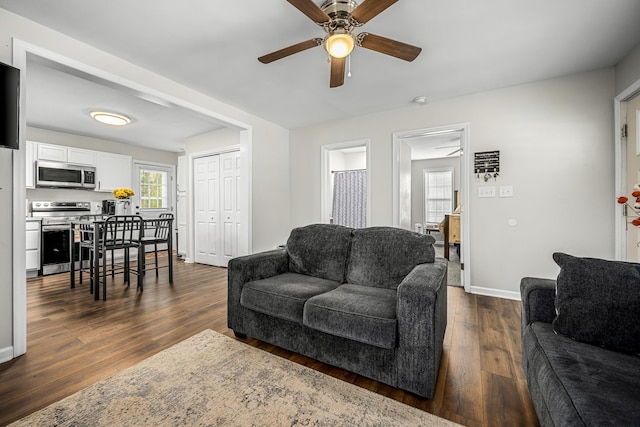 living room with ceiling fan and dark wood-type flooring