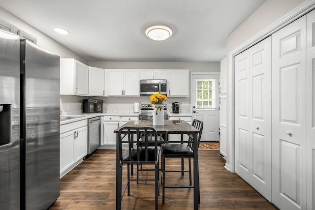 kitchen featuring white cabinetry, dark hardwood / wood-style flooring, and stainless steel appliances