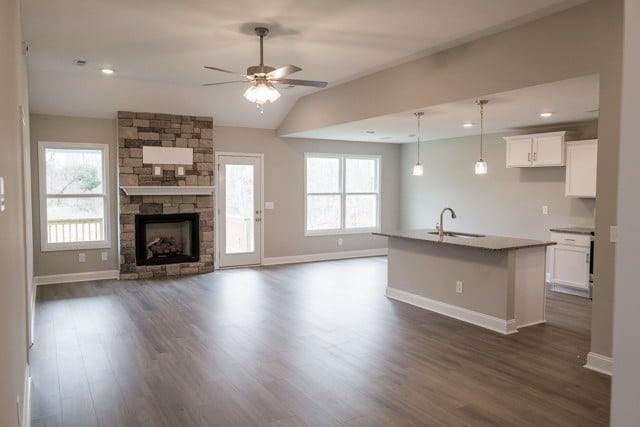 kitchen with white cabinetry, a kitchen island with sink, dark wood-type flooring, and pendant lighting