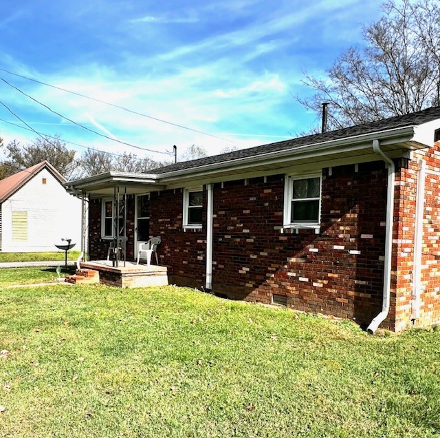 back of property with a yard and a patio area