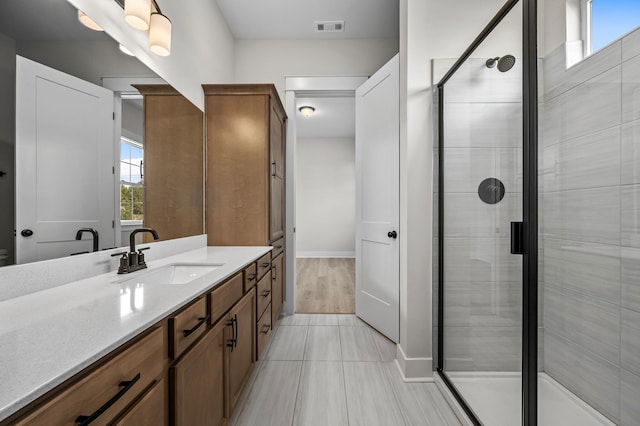 bathroom featuring walk in shower, wood-type flooring, and vanity