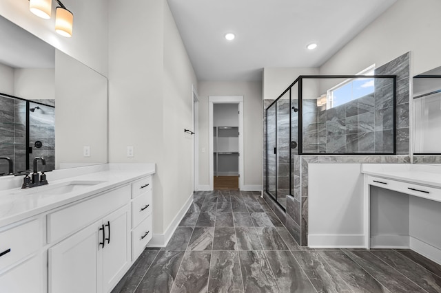 bathroom featuring a shower with shower door and vanity