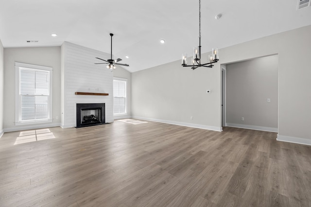 unfurnished living room with light hardwood / wood-style floors, ceiling fan with notable chandelier, a large fireplace, and vaulted ceiling