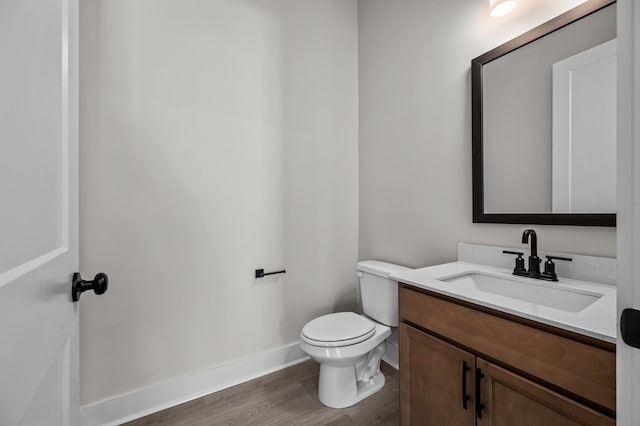 bathroom with hardwood / wood-style floors, vanity, and toilet