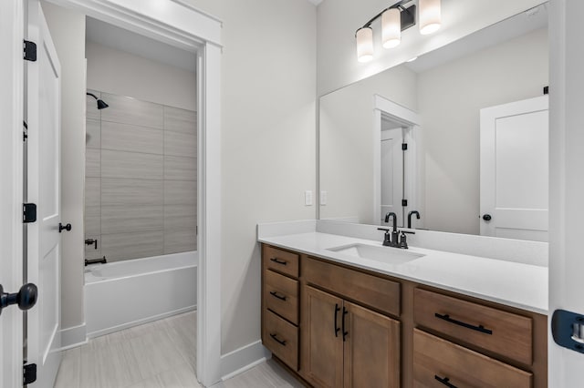 bathroom featuring tiled shower / bath combo and vanity