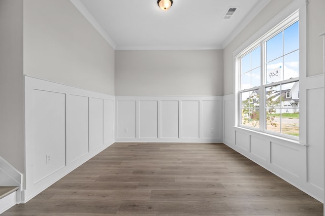 spare room featuring light hardwood / wood-style floors, a healthy amount of sunlight, and crown molding