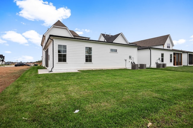 back of house featuring cooling unit and a lawn