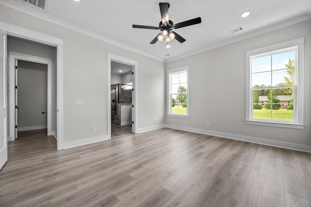 interior space with ceiling fan, multiple windows, light hardwood / wood-style flooring, and connected bathroom