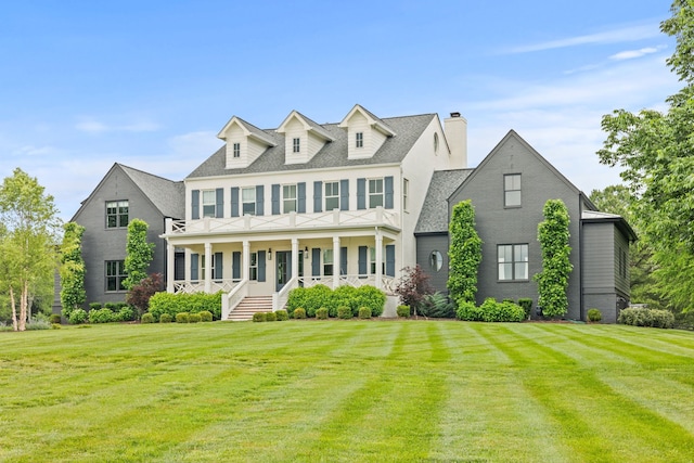 colonial inspired home with a porch and a front lawn