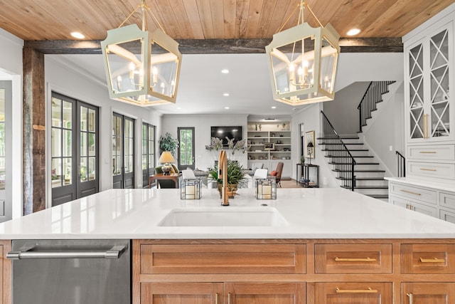 kitchen featuring white cabinets, beam ceiling, and an island with sink