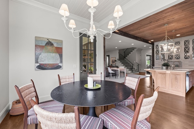 dining area with crown molding, a notable chandelier, dark hardwood / wood-style floors, wood ceiling, and sink