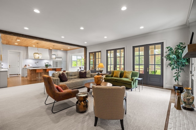 living room featuring french doors, crown molding, and light hardwood / wood-style flooring