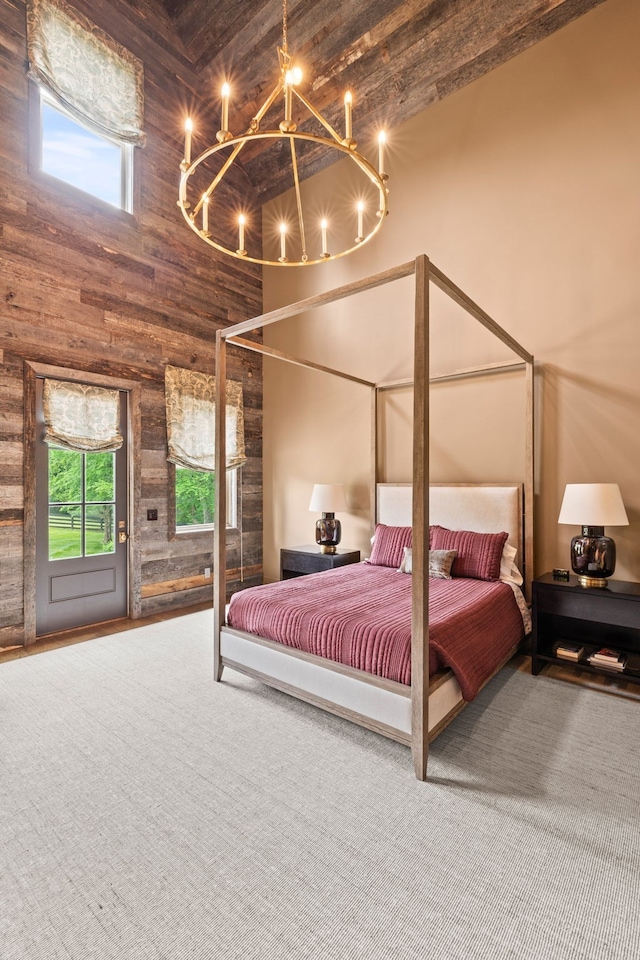 bedroom featuring wood walls, a chandelier, and a towering ceiling