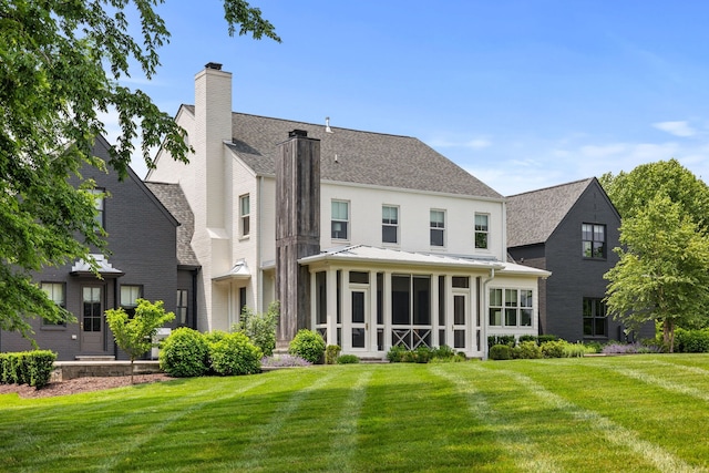 back of house with a lawn and a sunroom