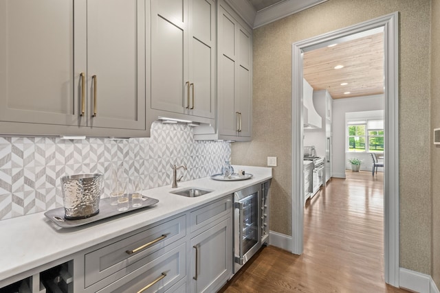 bar featuring ornamental molding, wine cooler, dark hardwood / wood-style floors, gray cabinets, and sink